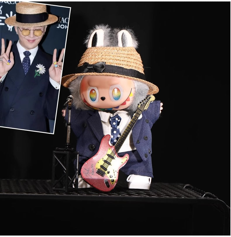 Labubu wearing a handmade G-Dragon inspired outfit – bold K-pop streetwear style with detailed accessories. Photo with G-Dragon on stage with guitar.